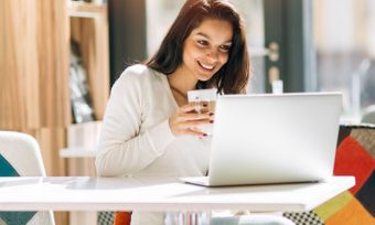 Woman using laptop in cafe