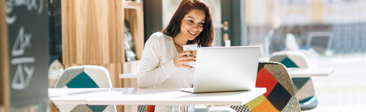 Woman using laptop in cafe