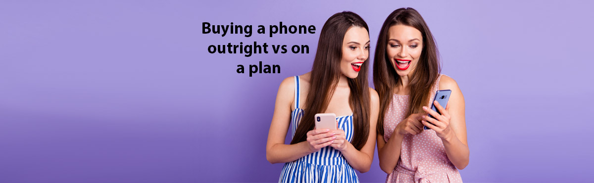 Young women looking at smartphones against purple background