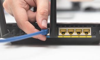 Closeup of person plugging cord into modem