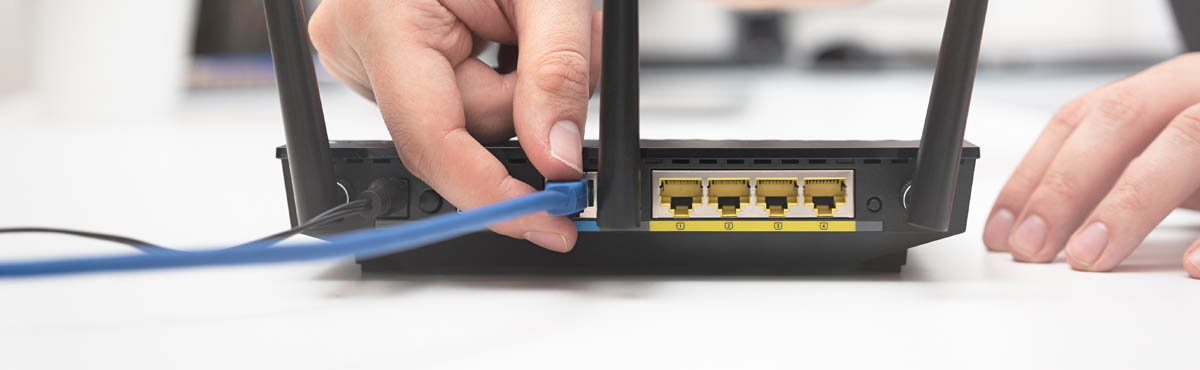 Closeup of person plugging cord into modem