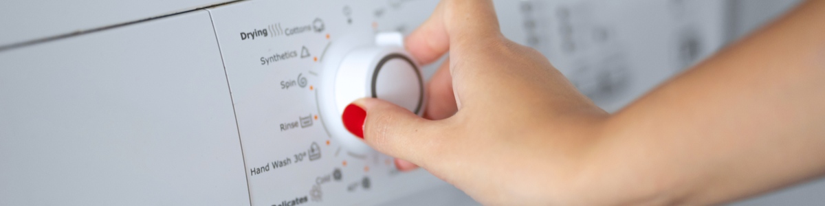 Lady's hand turning a washing machine nozzle