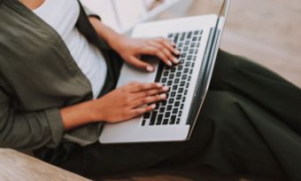 Woman using laptop on staircase