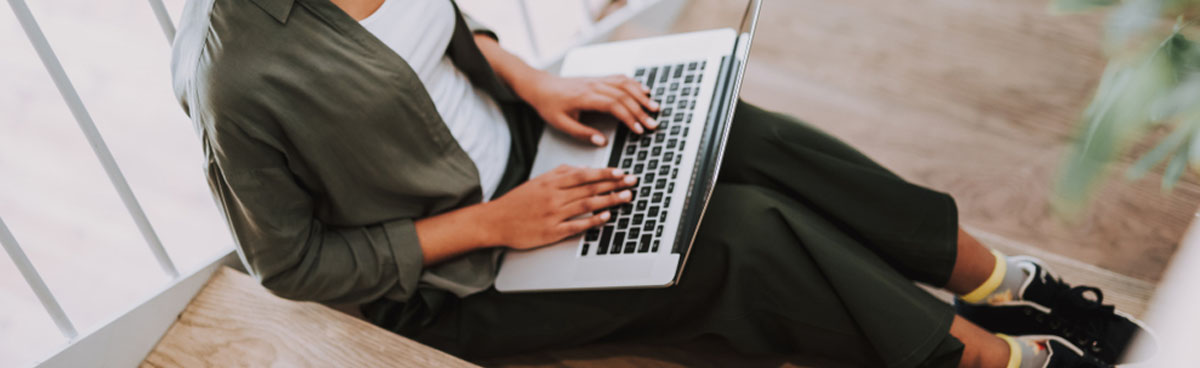 Woman using laptop on staircase