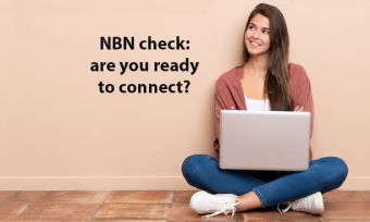 Woman using laptop while sitting cross-legged on floor