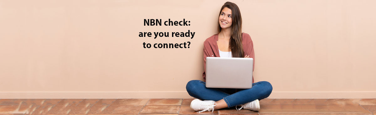 Woman using laptop while sitting cross-legged on floor