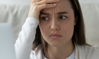 Young lady looking disappointed at laptop screen