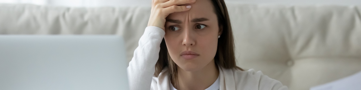 Young lady looking disappointed at laptop screen