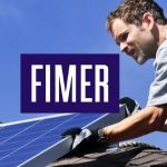 Man installing solar panels on roof of house with Fimer logo