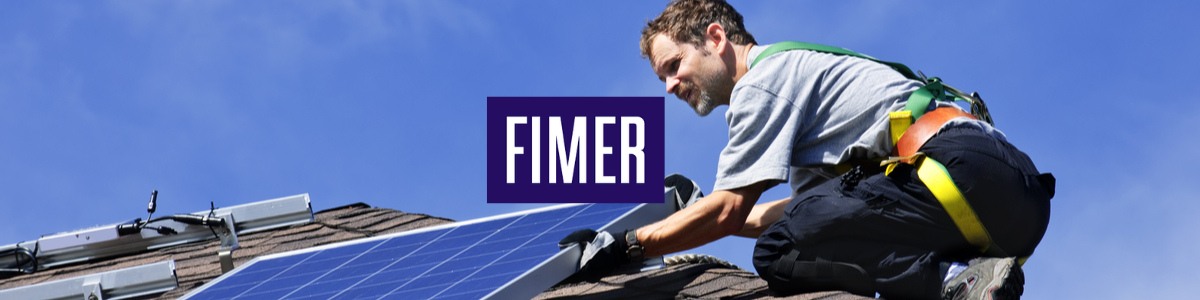 Man installing solar panels on roof of house with Fimer logo