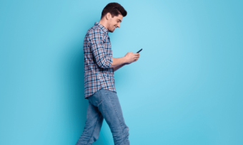 Image for Telstra eSIM activation showing man holding phone against blue background