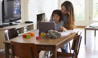 Young mother with child watching using laptop