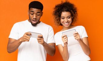 Happy young couple looking at phones together