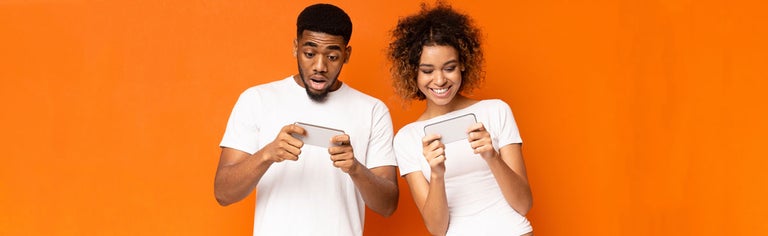 Happy young couple looking at phones together