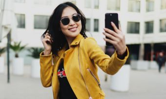 Smiling woman using smartphone in public