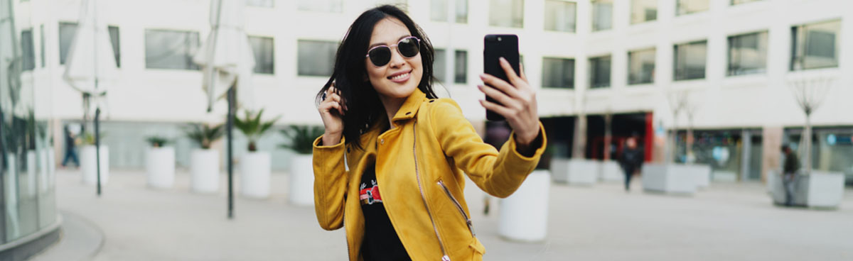 Smiling woman using smartphone in public