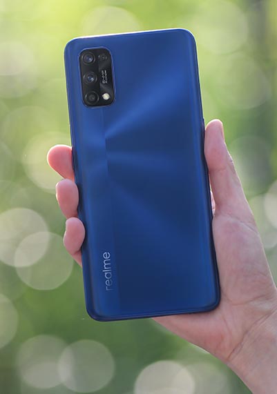 Realme 7 Pro phone in blue held in hand outside