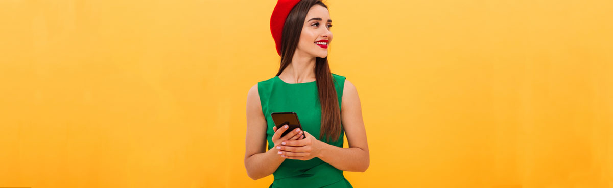 Young woman with phone wearing green dress and red beret