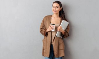 Young woman holding tablet and coffee