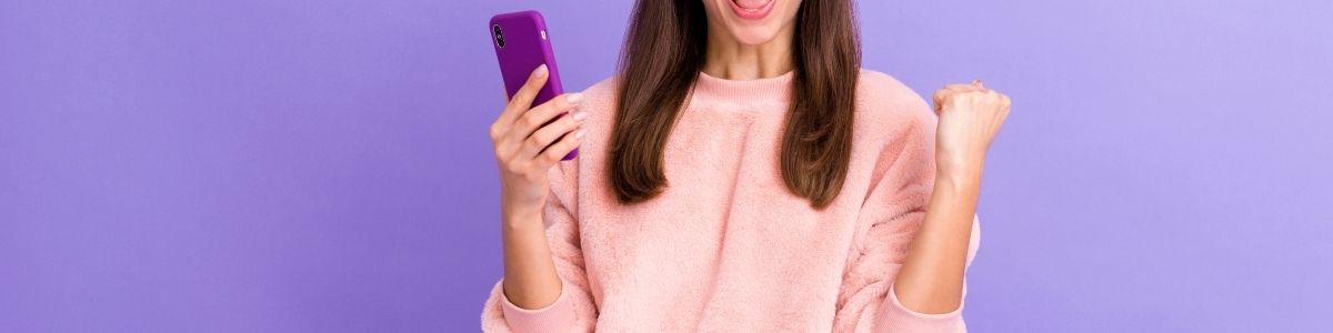 A woman using a phone in front of a purple background