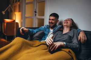 Couple laughing at TV