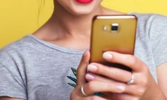 A woman using a golden phone