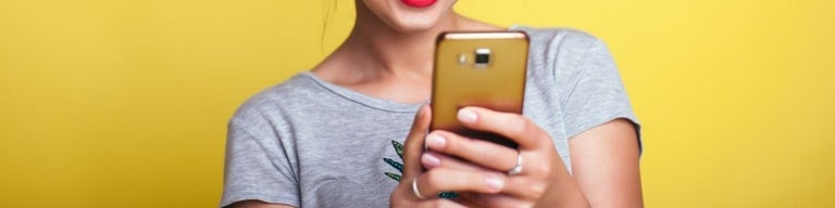 A woman using a golden phone