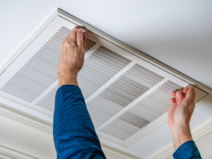 Hands removing ducted air conditioning vent