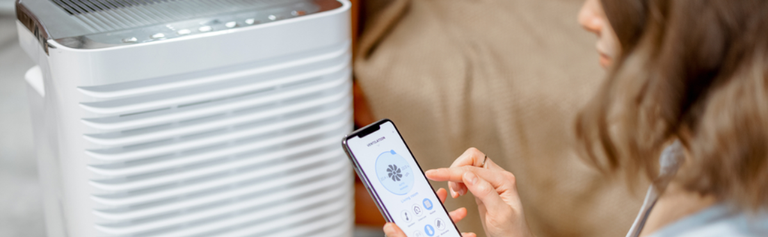 Woman setting temperature on cooler with phone