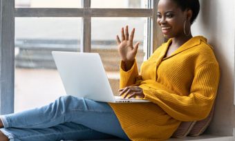 Young woman using laptop to video chat