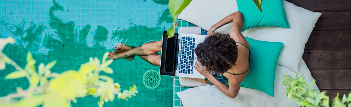 Overhead view of woman using laptop by pool