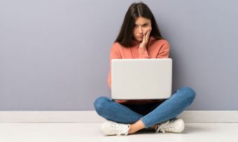 Girl with disappointed expression using laptop