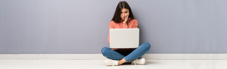 Girl with disappointed expression using laptop