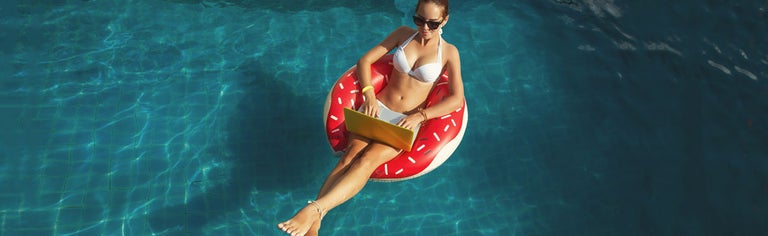 Woman floating in pool with laptop