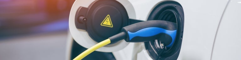 Electric vehicle charger plugged into car