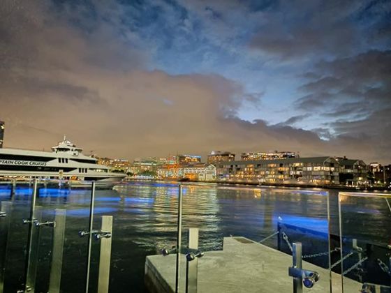 Night shot of boat on water with city in background