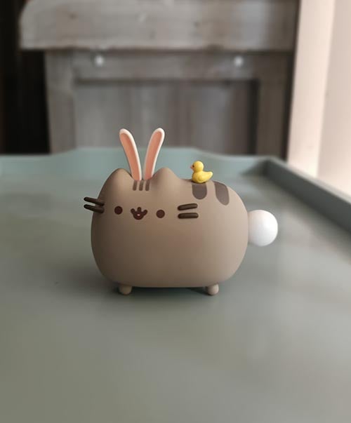 Portrait shot figurine of cat with bunny ears and tail