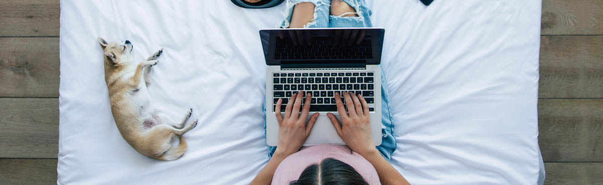 Woman at home using laptop on bed