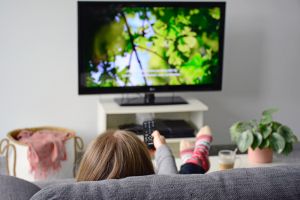 Woman watching TV with subtitles