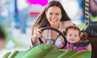 Mother and child in dodgem car at amusement park