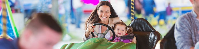 Mother and child in dodgem car at amusement park