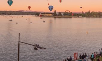 Hot air balloons over Canberra skyline at sunrise