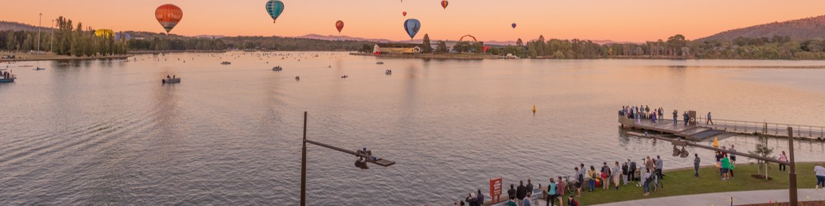 Hot air balloons over Canberra skyline at sunrise