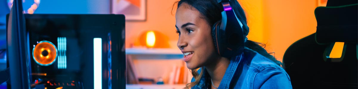 Young female gamer wearing headset playing computer game