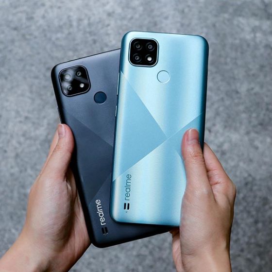 Person holding blue and black Realme C21 phones