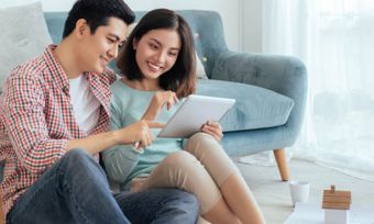 Happy young couple watching tablet together