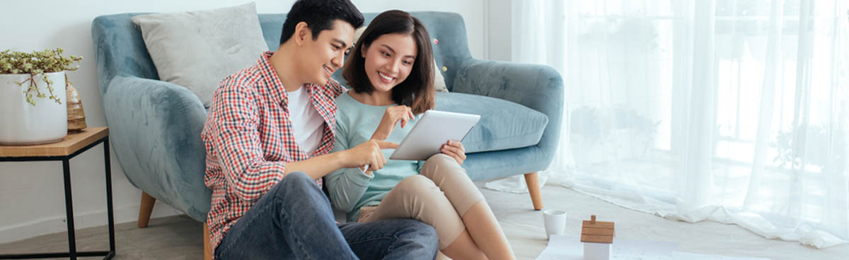 Happy young couple watching tablet together