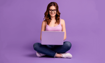 Woman using laptop against purple background