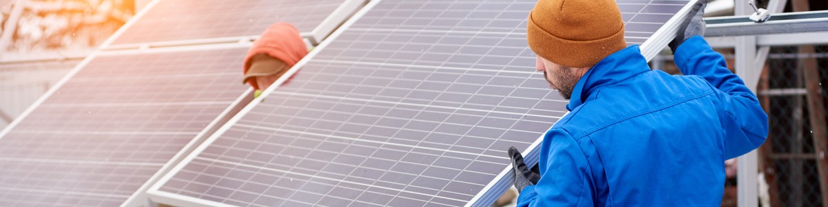 People removing solar panels from roof