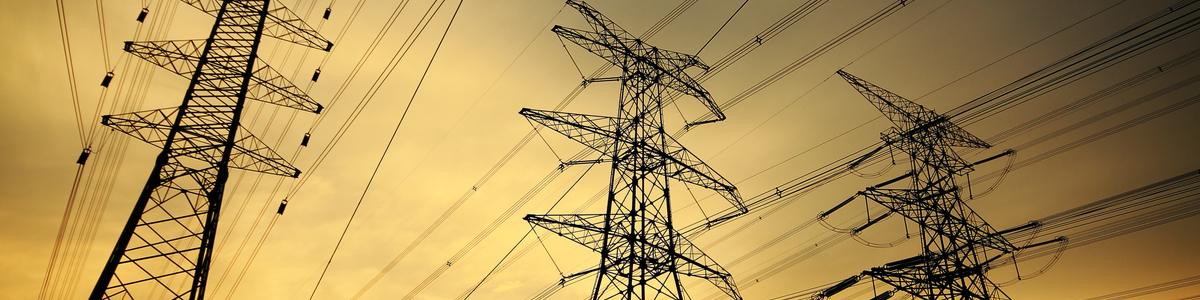 Electricity towers and wires at sunset